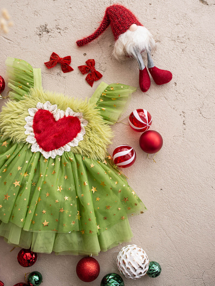 Miss Grump green tulle dress with gold stars and a red fur heart, surrounded by red and green Christmas baubles - Before & Ever Kids