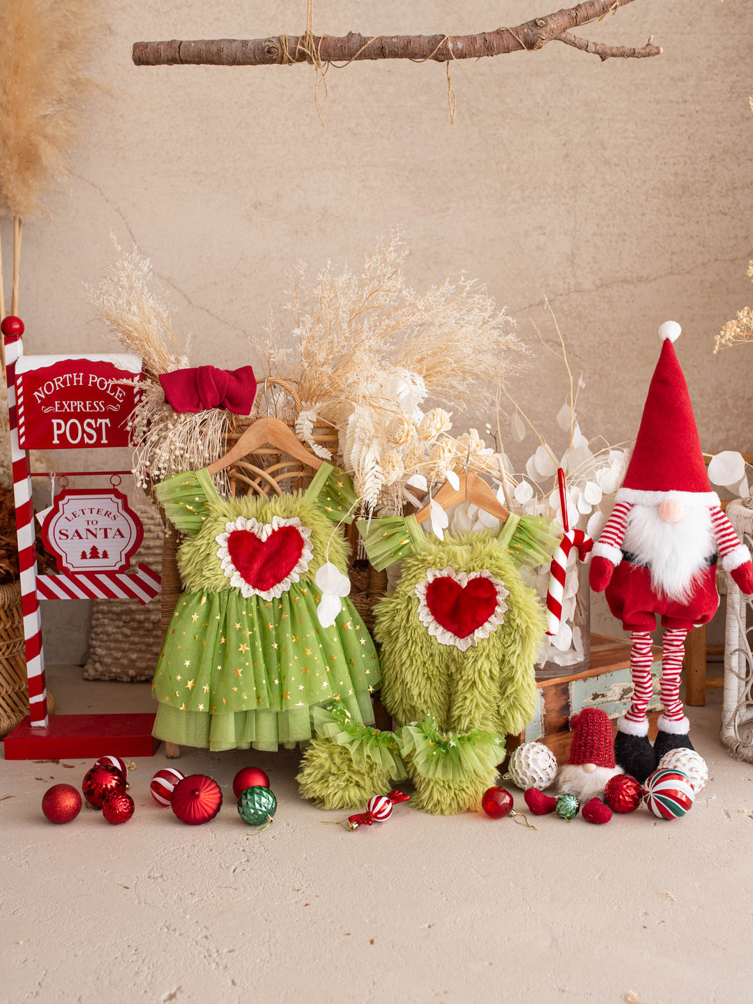 Matching Miss Grump Christmas dress and Little Grump romper hanging together with a Santa gnome, a candy cane and red baubles - Before & Ever Kids