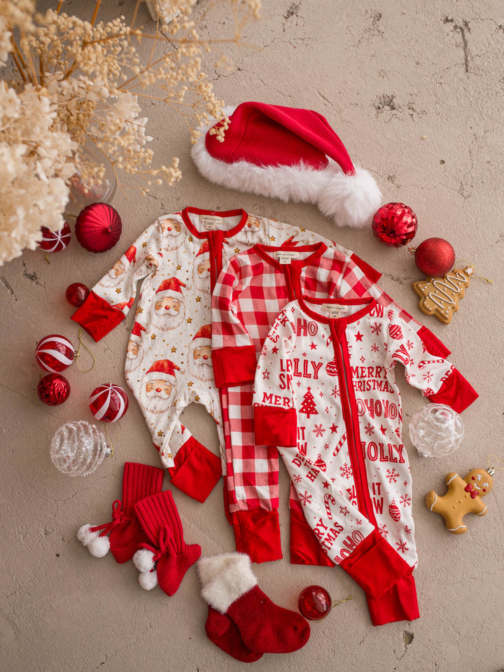 All I Wish Christmas baby onesies laid out together including the Jolly print - Before & Ever Kids
