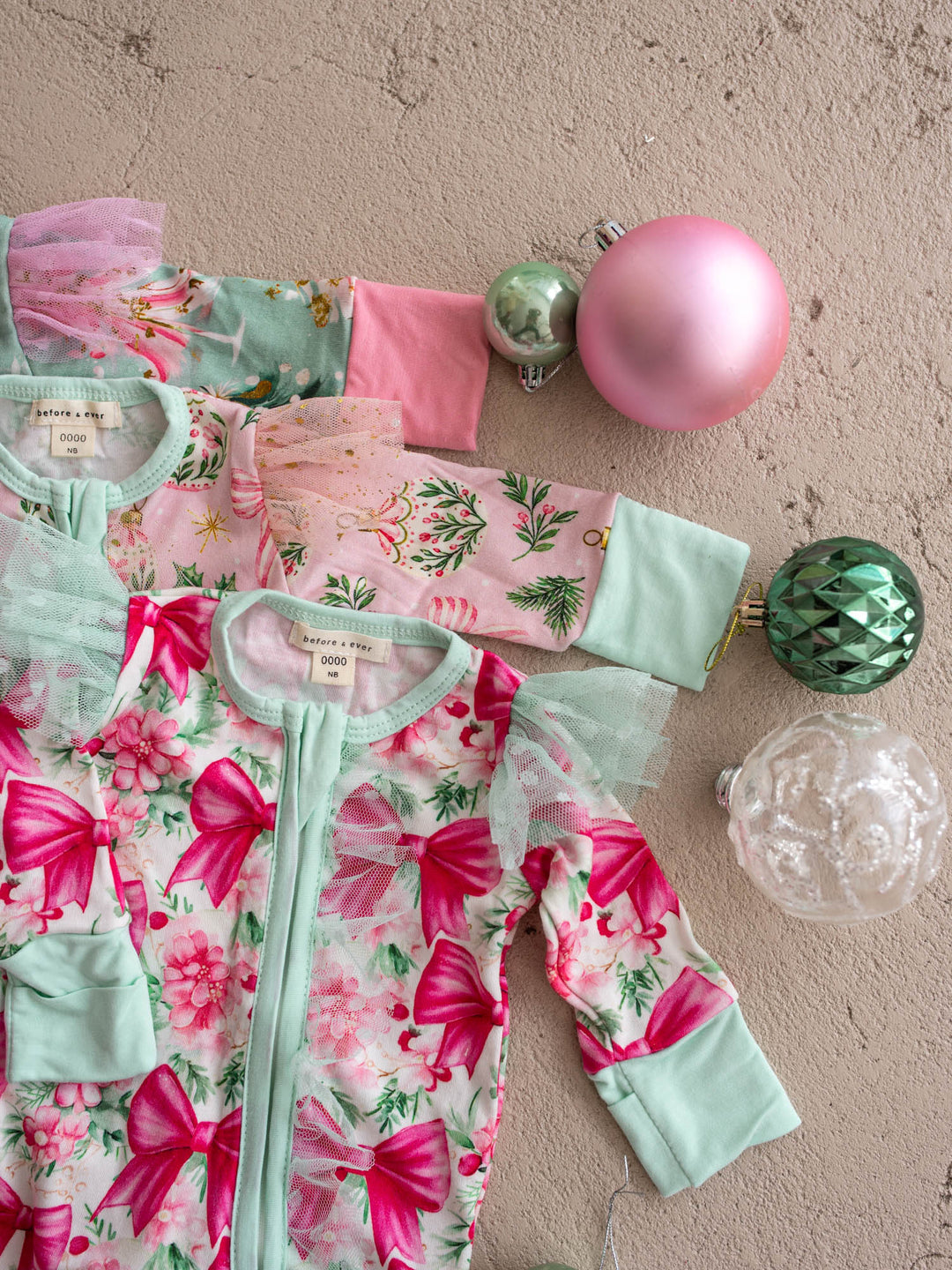 All I Wish Christmas baby onesies and topknots laid out together including the Mint Pine print - Before & Ever Kids