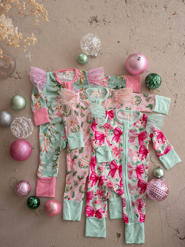 All I Wish Christmas baby onesies and topknots laid out together including the Pink Holly print - Before & Ever Kids
