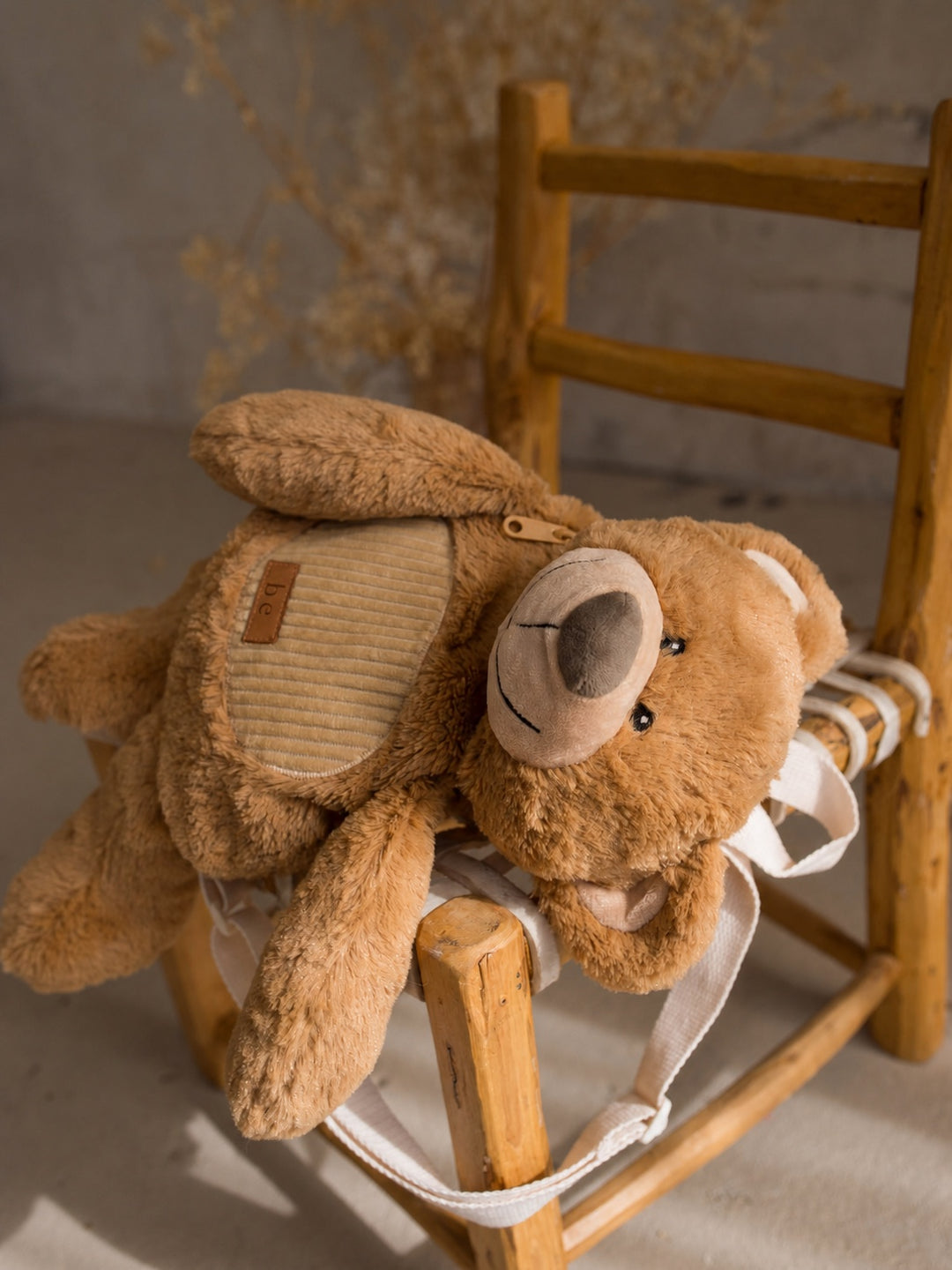 Beau the Bear plush backpack for kids, bear sidekick backpack resting on a chair - Before & Ever Kids