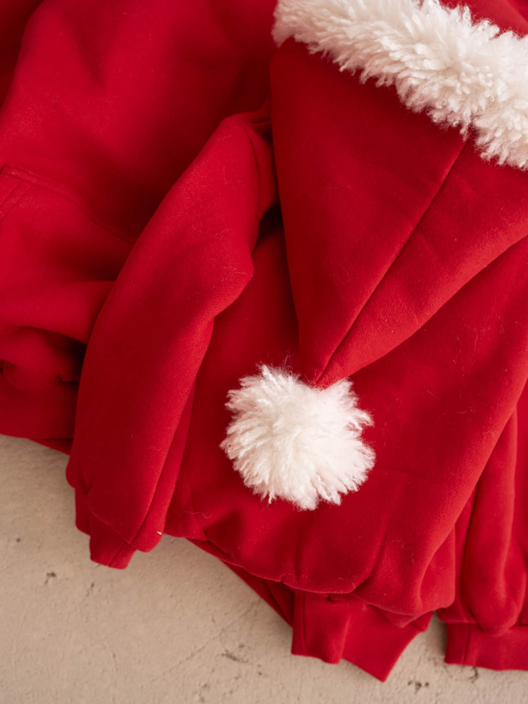 Close up of the white pom-pom on the Ho Ho Hoodie Santa hat hood - Before & Ever Kids
