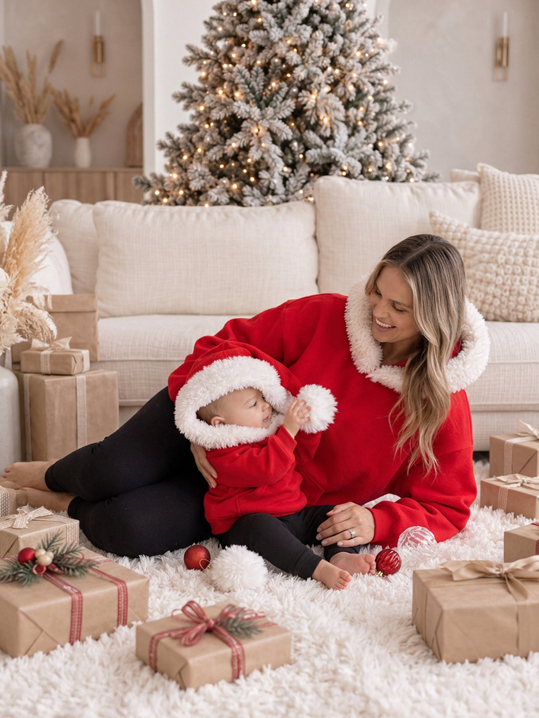 Ho Ho Hoodie red adult hoodie worn with the hood down, a mum sitting with a baby in the matching kids hoodie - Before & Ever Kids