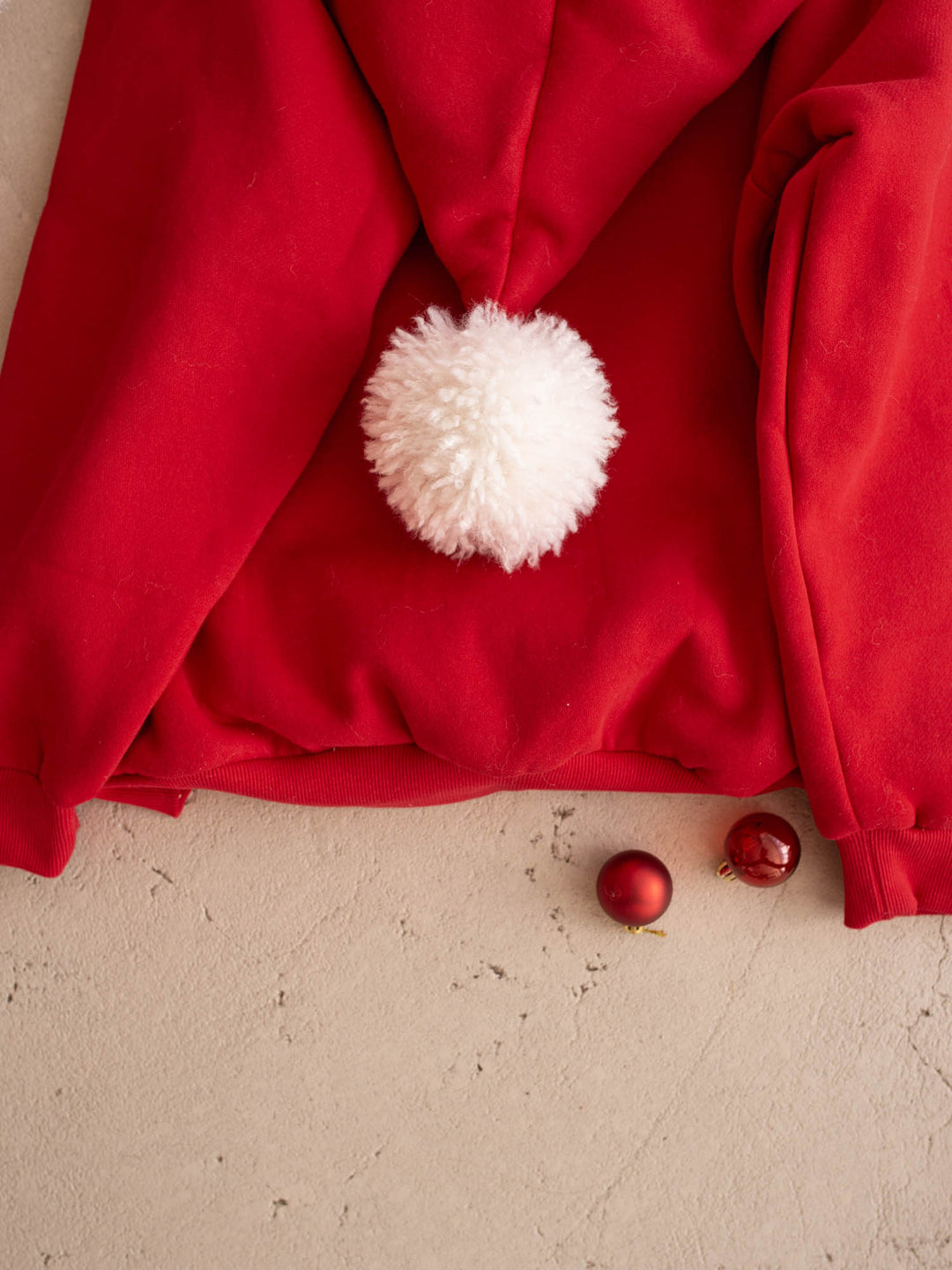 Close up of the white pom-pom on the Ho Ho Hoodie adult, back - Before & Ever Kids