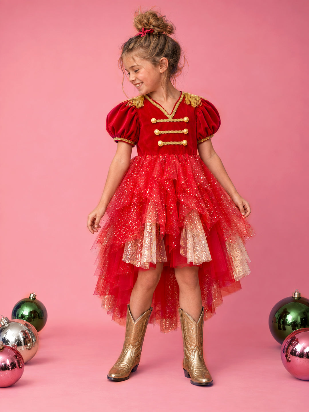 Little Drummer red front view on model, red velvet bodice with gold military braid and epaulettes over a high low red and gold glitter tulle skirt, worn with gold cowboy boots - Before & Ever Kids