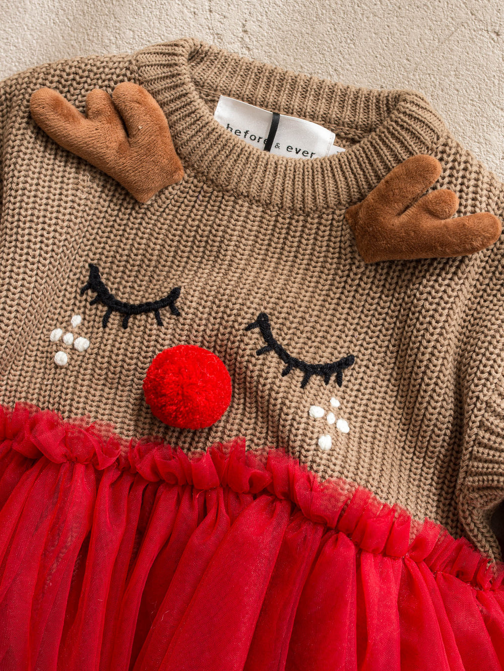 Little Reindeer Sweater brown and red camel knit sweater with an embroidered sleeping reindeer face, felt antlers and a red tulle frill across the front - Before & Ever Kids
