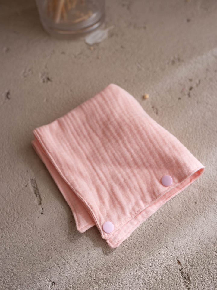 Macie the Bunny Little BFF Companion Backpack, the matching pink muslin comforter that doubles as a bib or a bandana, folded