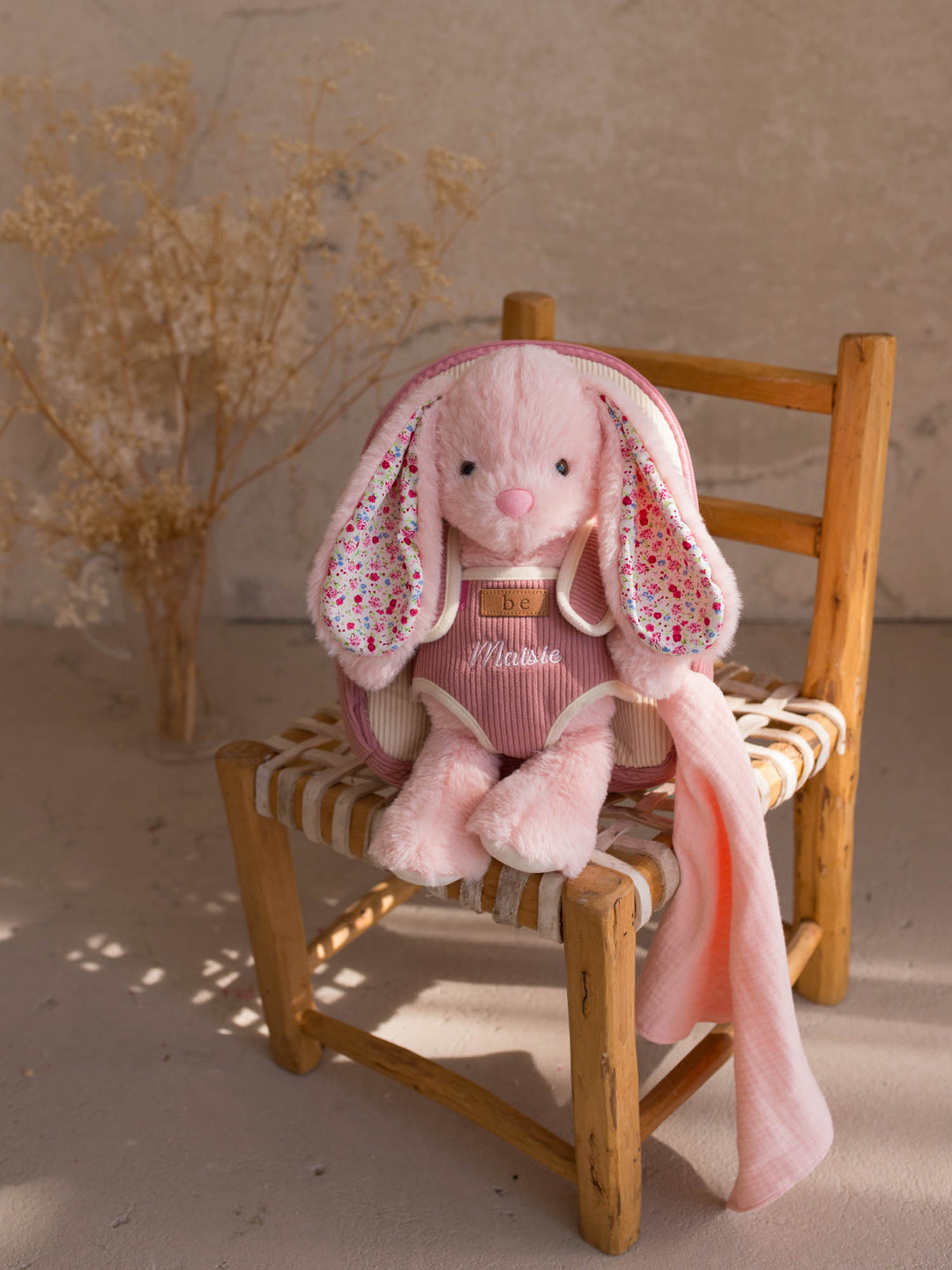 Macie the Bunny personalised plush backpack for kids, bunny sitting on a chair with the backpack - Before & Ever Kids