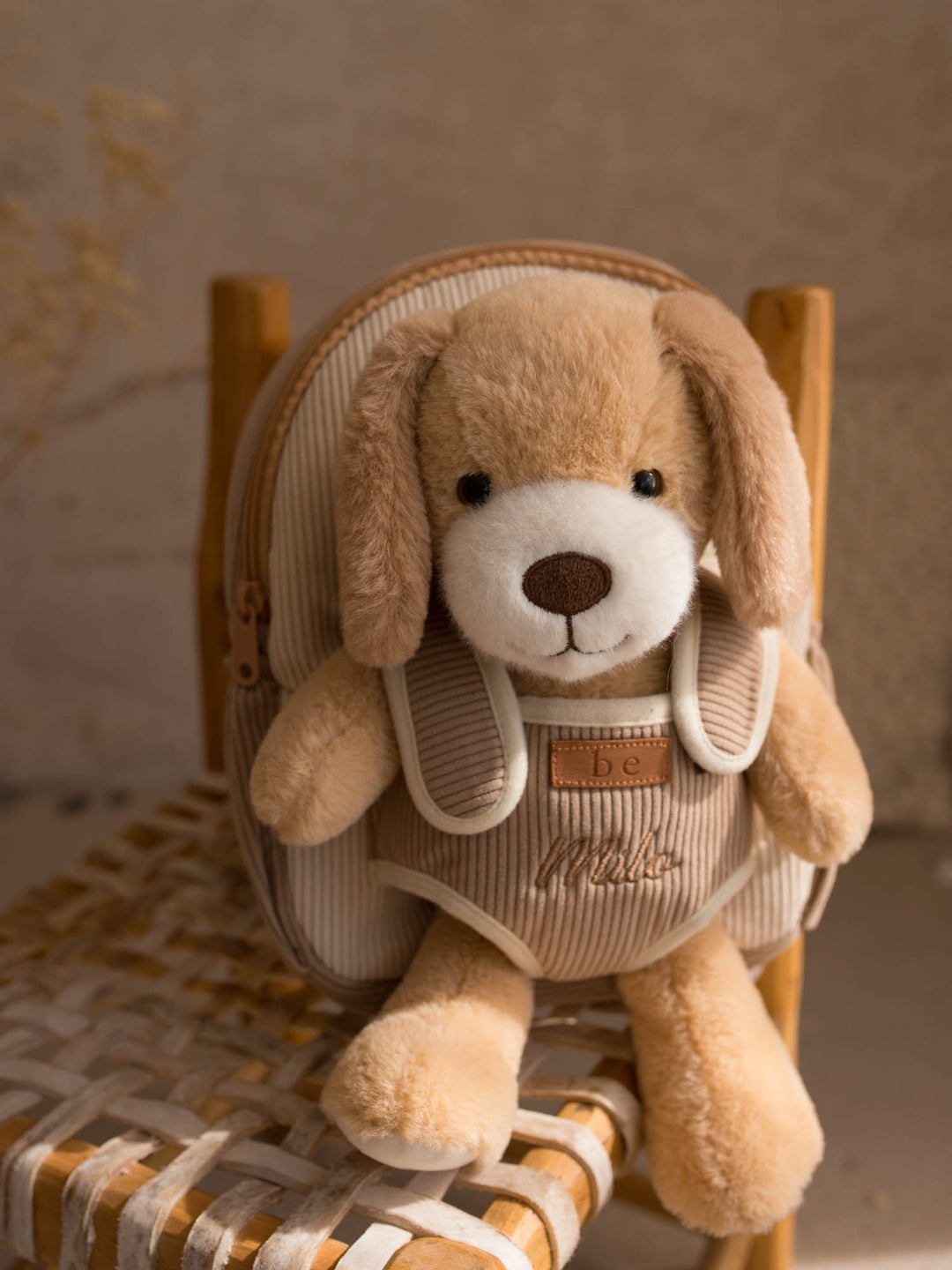 Milo the Puppy personalised plush backpack for kids, front view with the plush puppy in the front pocket - Before & Ever Kids