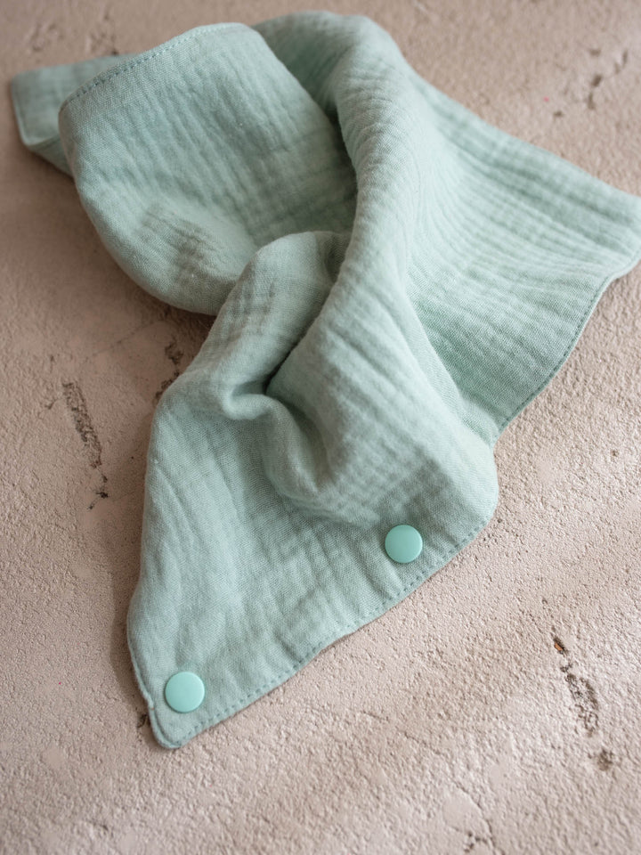 Sage the Horse Little BFF Companion Backpack, the matching sage green muslin comforter that doubles as a bib or a bandana, spread open showing the snap fastening