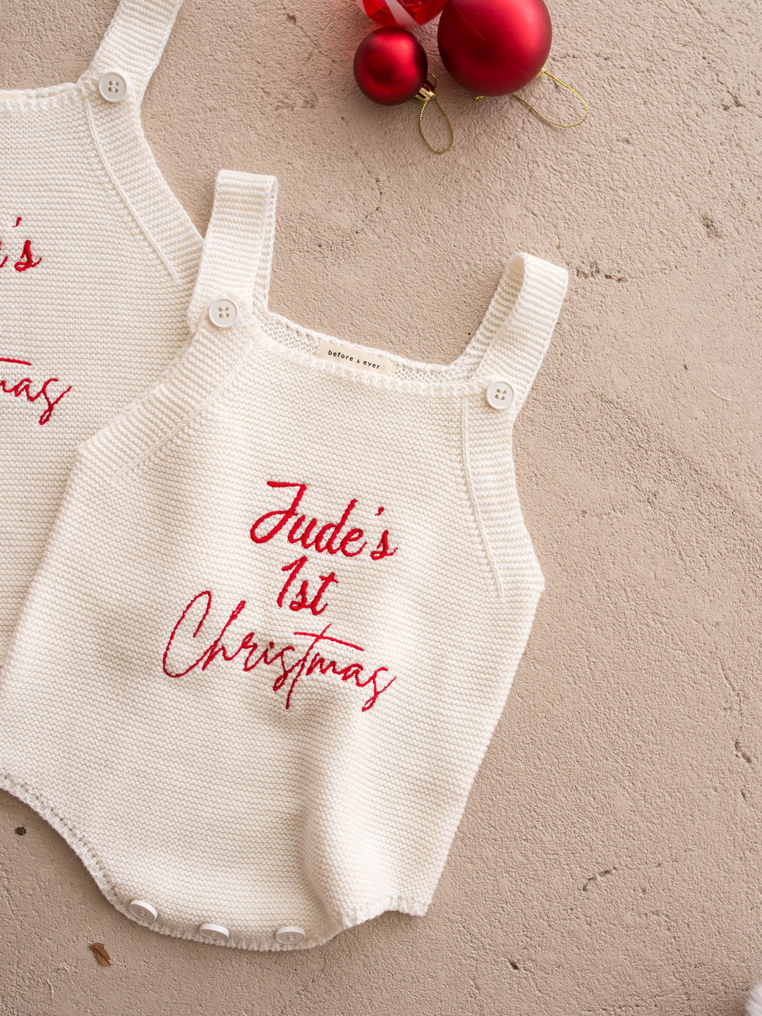 Say My Name Christmas Singlet Romper in milk cotton knit with a personalised name in red, laid flat, full front, personalised name embroidered in red - Before & Ever Kids