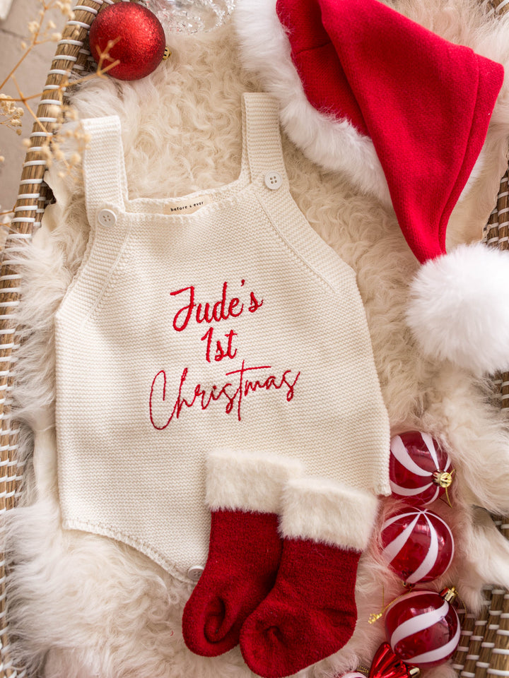 Say My Name Christmas Singlet Romper in milk cotton knit with a personalised name in red, on a fur rug with red pom pom booties - Before & Ever Kids