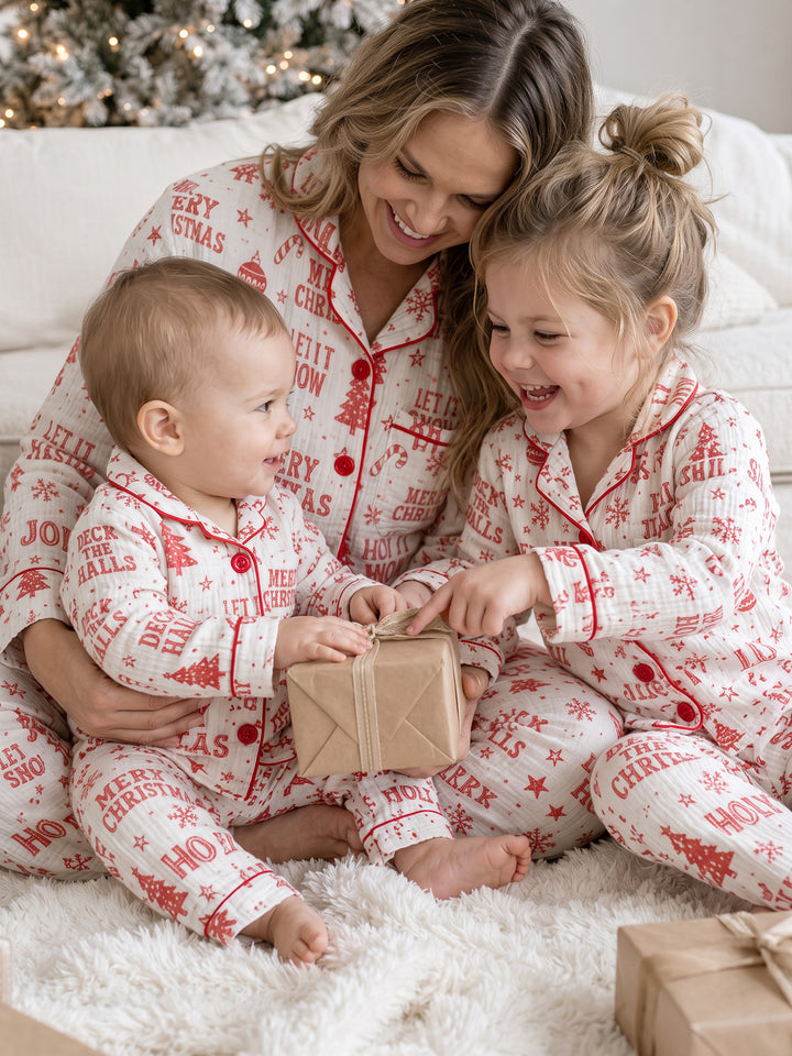 Twas the Night family Christmas pyjamas, white cotton muslin with a red Christmas print, mum in long sleeves with the girl and baby unwrapping a present - Before & Ever Kids