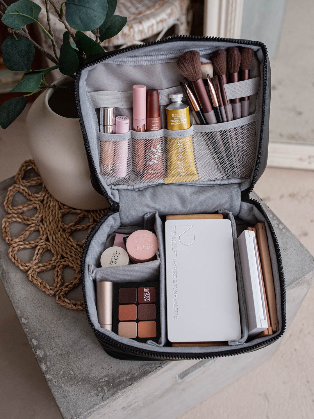 The Before & Ever makeup bag, open, with removable dividers and brush pockets